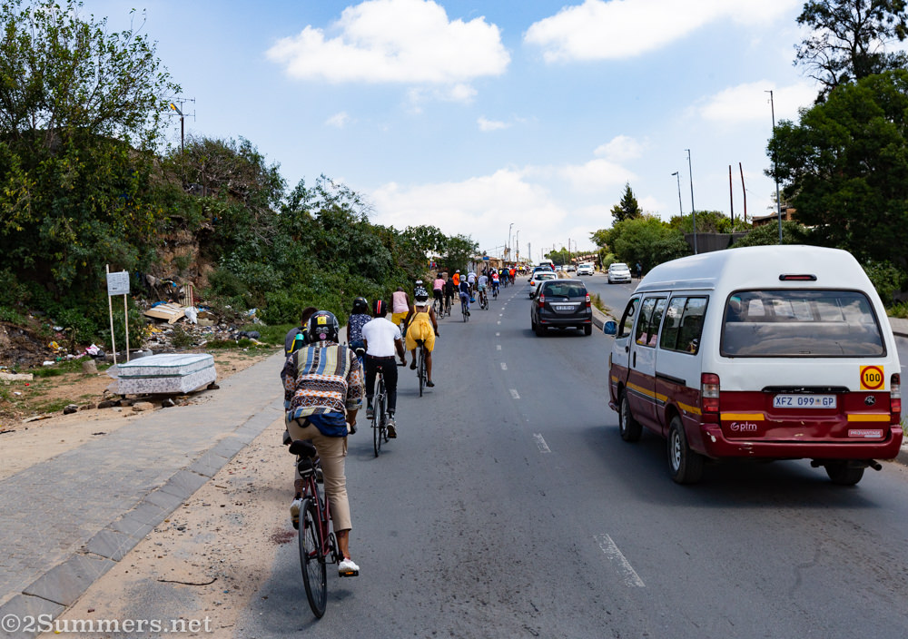 Cyclists riding up a hill in Alexandra Township.