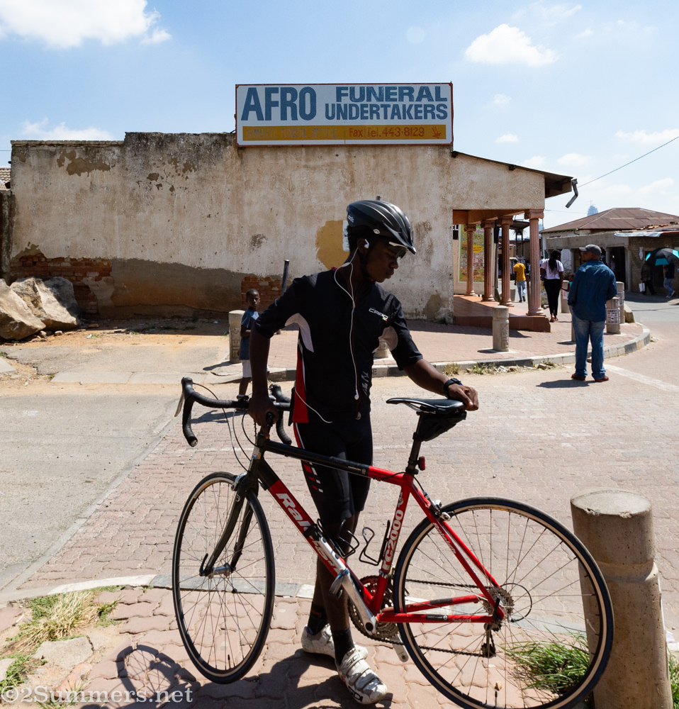 Cyclist in front of a funeral home in Alexandra Township
