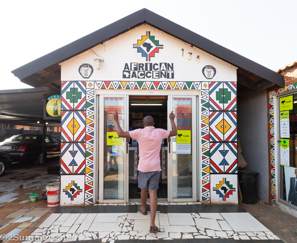 Guy walking into African Accent spaza shop in Katlehong