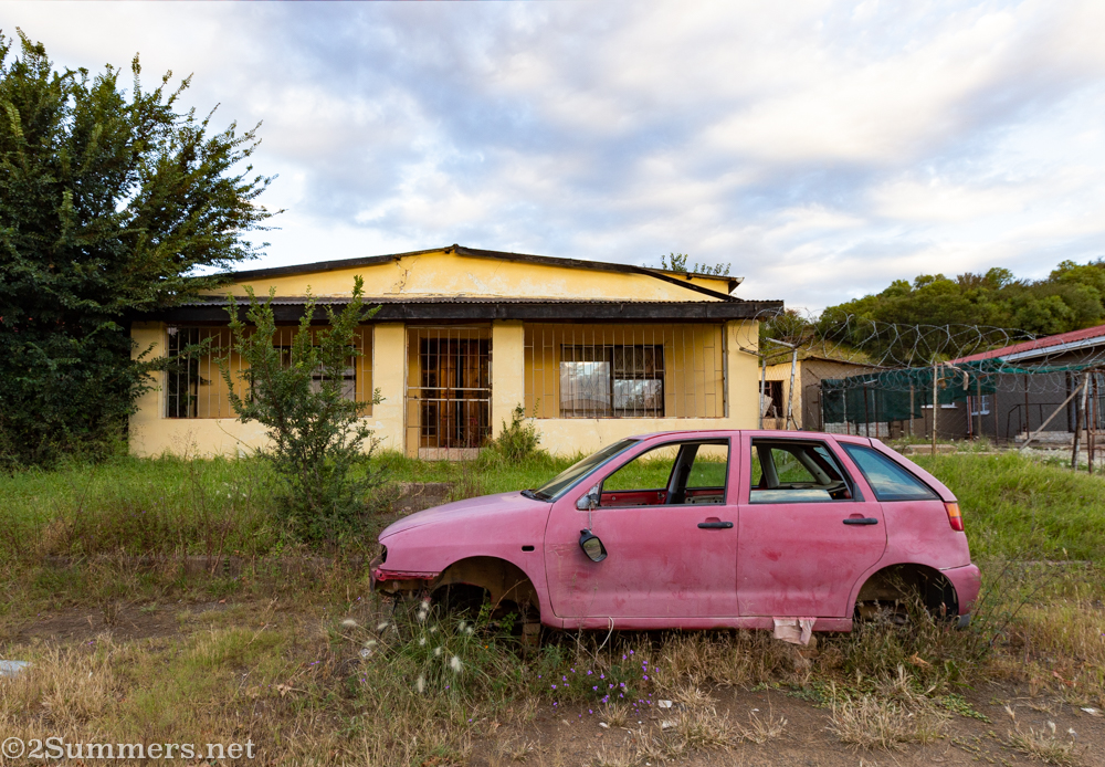 House and broken down pink car