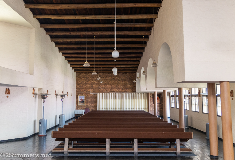 Around the nave are three asymmetrical galleries with long rows of benches facing toward the pulpit. Flo pointed out that the design is very elegant but also built with simple, economical materials -- like the humble gum poles used as ceiling beams.