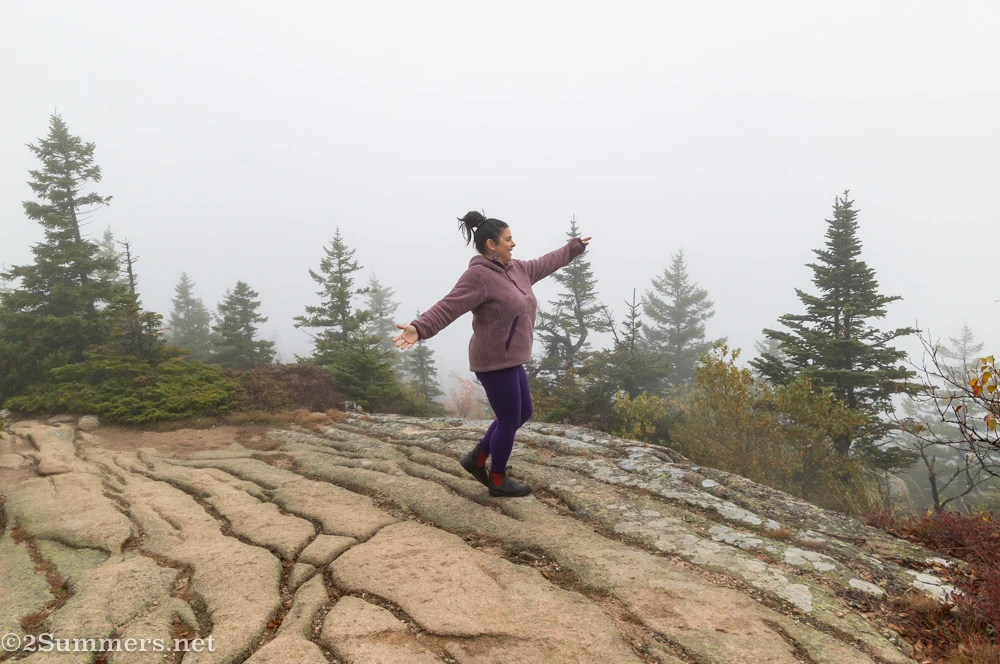 Susanna standing in thick fog at the top of Cadillac Mountain